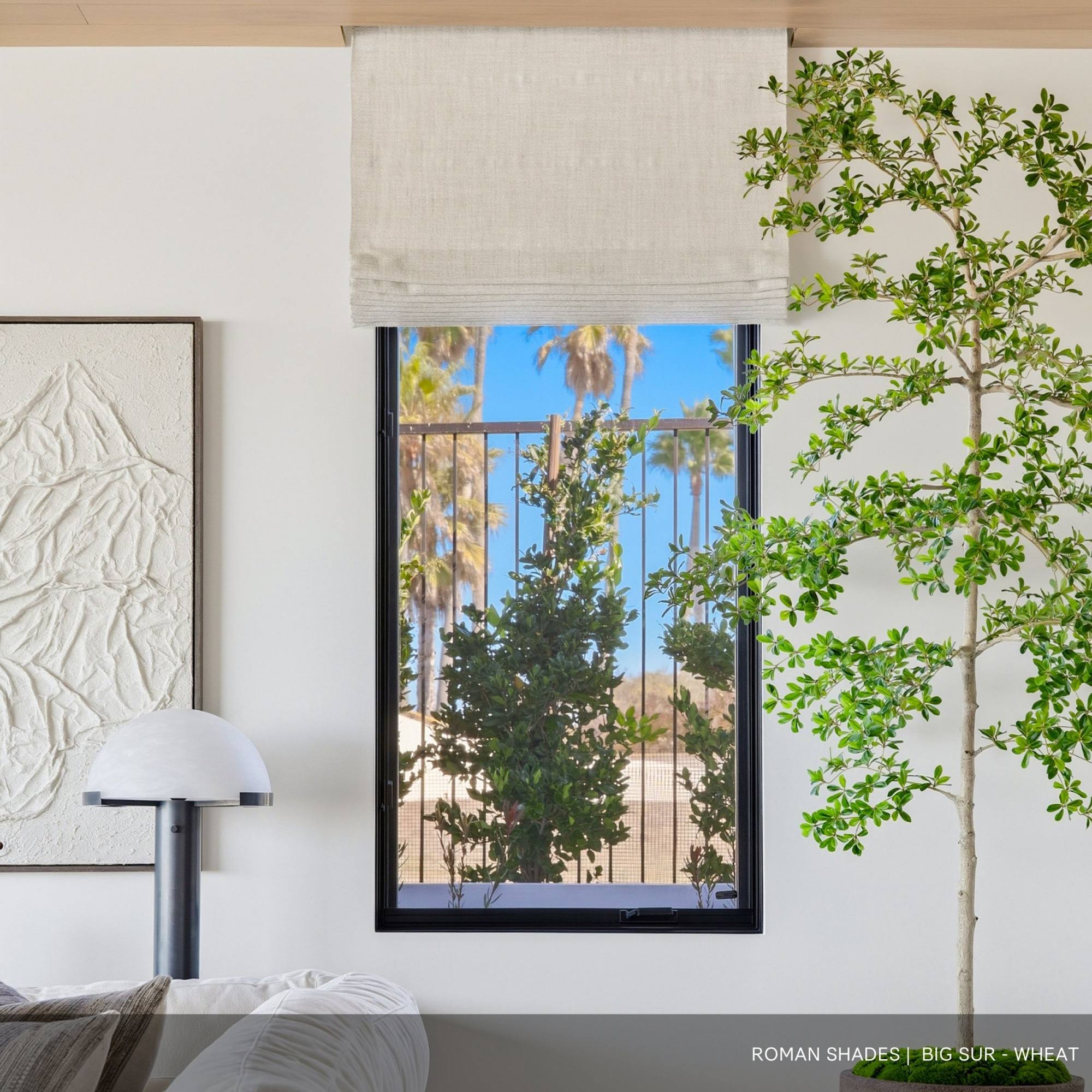 An open Roman Shades in a window with a tree and fence