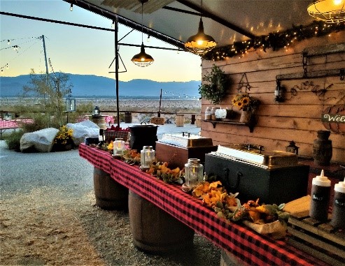 A group of people enjoying an adventurous Covered Wagon Tour, accompanied by lively entertainment and savoring delicious BBQ